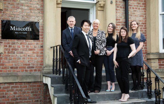 New starters at Mincoffs, standing on steps