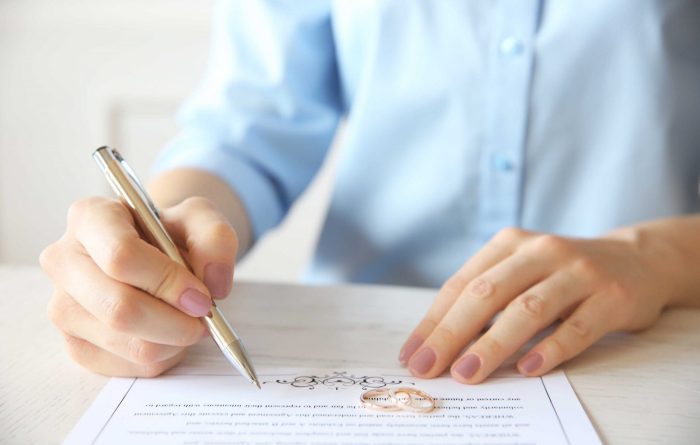 Woman signing pre-nuptial agreement - Mincoffs Solicitors Family Law team