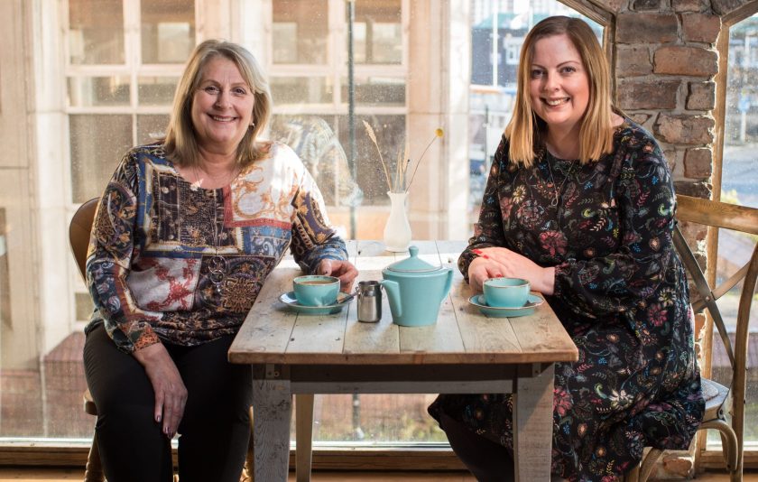 Emma Liddle and Una Coulson sitting at a table drinking coffee