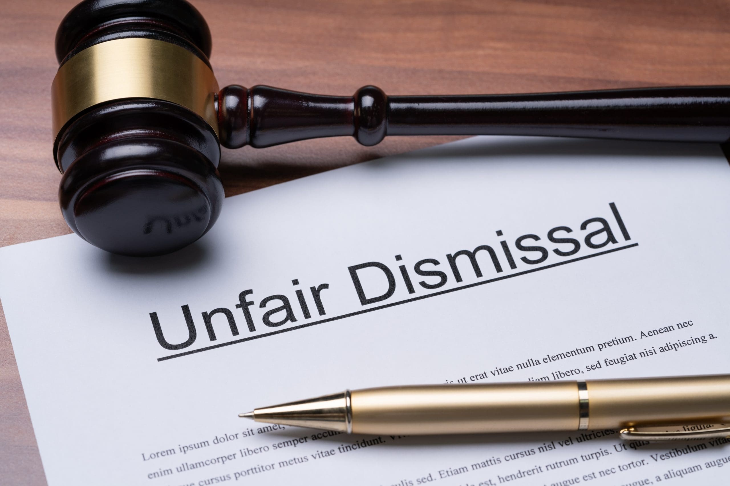 Documents of unfair dismissal with gavel and pen